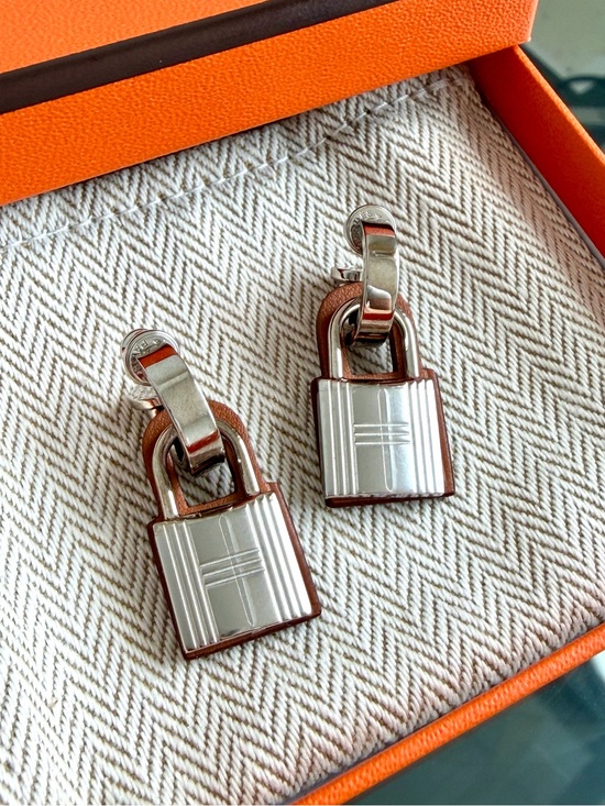 Hermes Jewelry - Hermès O’ Kelly earrings. Palladium and Gold Swift Leather 🍊